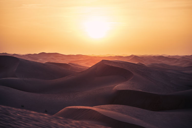 Heat day in desert landscape. sand dunes at beautiful sunset. abu dhabi, united arab emirates