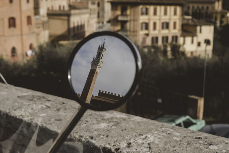 Torre del mangia reflecting on vehicle mirror