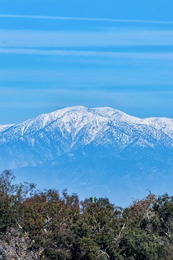 Scenic view of snowcapped mountains against blue sky