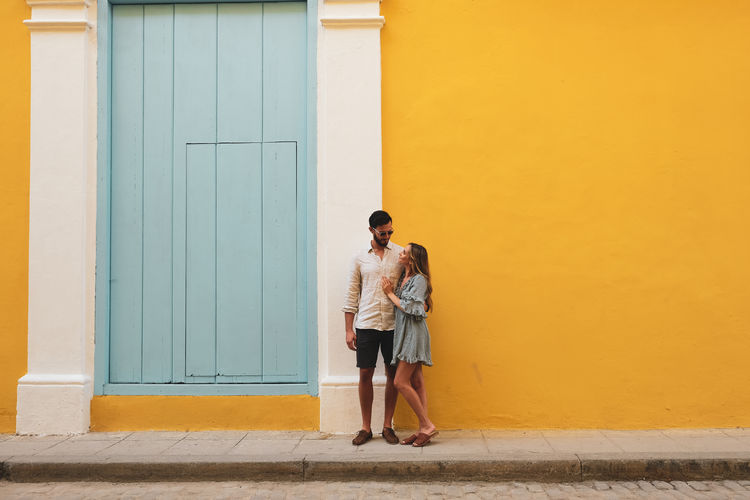 Full length of couple standing against door