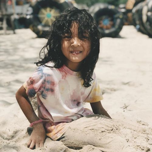 Portrait of a smiling girl lying on sand