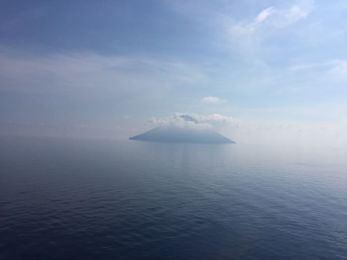 Scenic view of stromboli volcanic island against cloudy sky