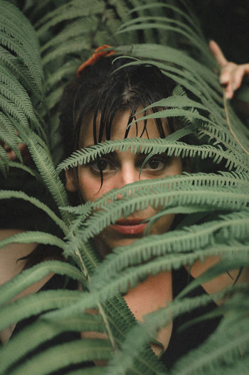 Close-up portrait of woman standing by plants