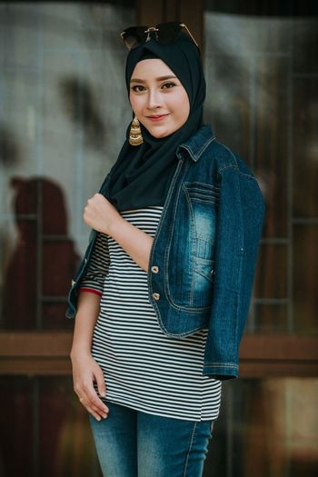 Portrait of smiling woman in hijab standing outdoors