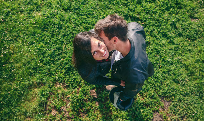 Man kissing woman while standing on lawn