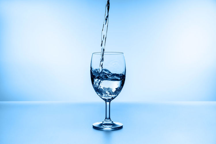Close-up of wine glass against blue background