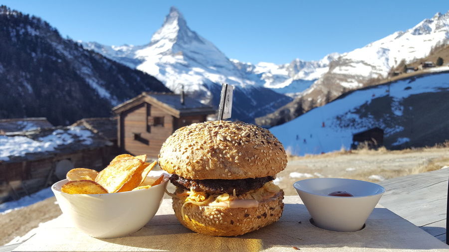 Close-up of food served on table against mountains