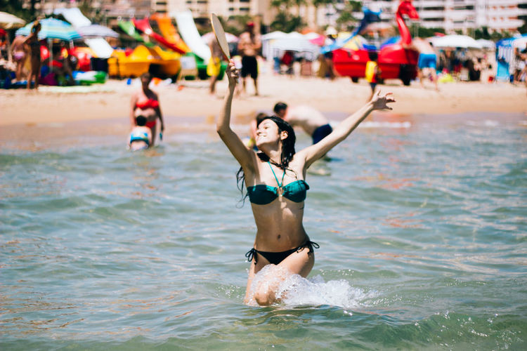 Happy young bikini woman playing in sea