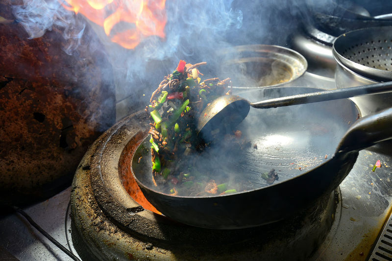 A chef in xinjiang is frying a delicacy quickly.