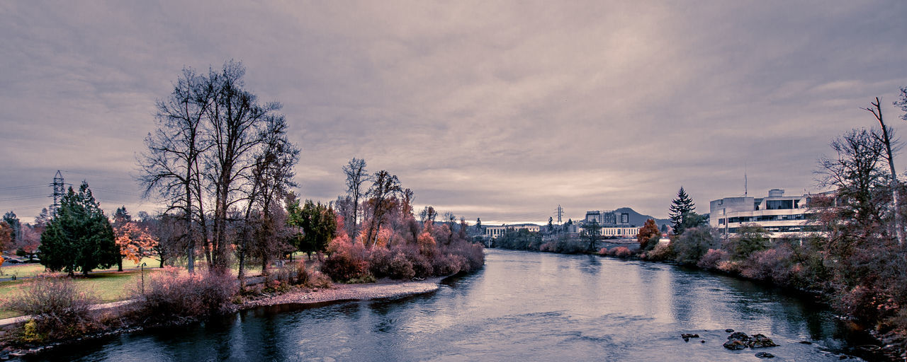 River amidst buildings in city against sky