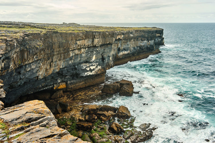 Rock formations by sea against sky