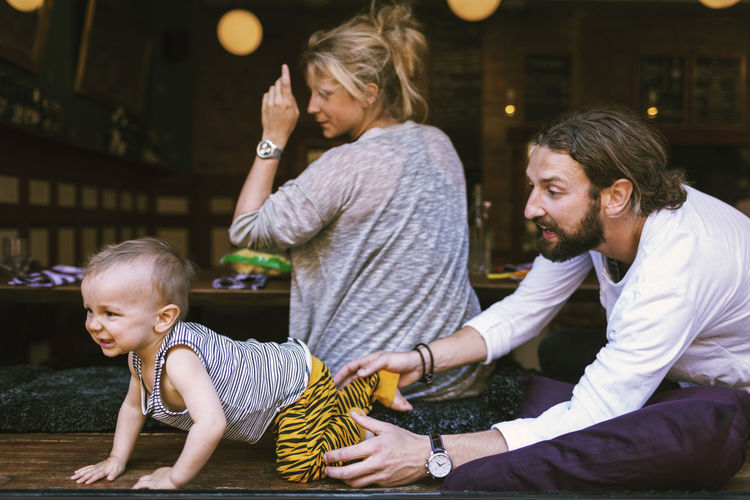 Mid adult parents with playful son in restaurant