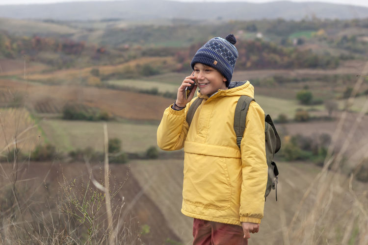 Young man using mobile phone while standing on land