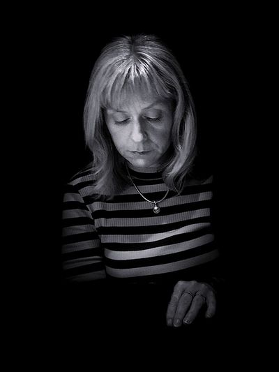 Thoughtful mature woman against black background