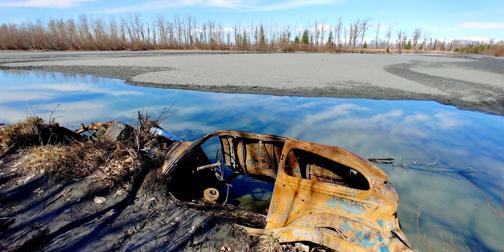 Abandoned car by lake during winter