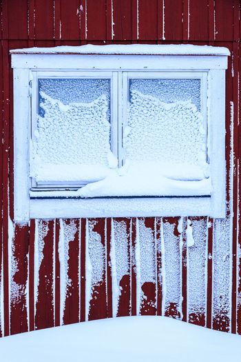 Snow covered window of house