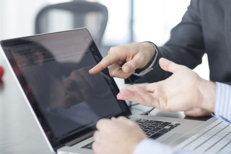 Colleagues in office pointing at laptop screen