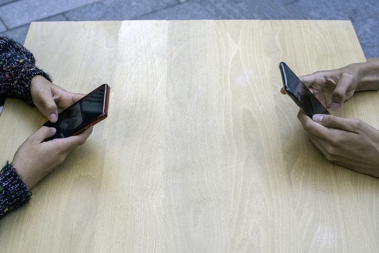 High angle view of man using mobile phone on table