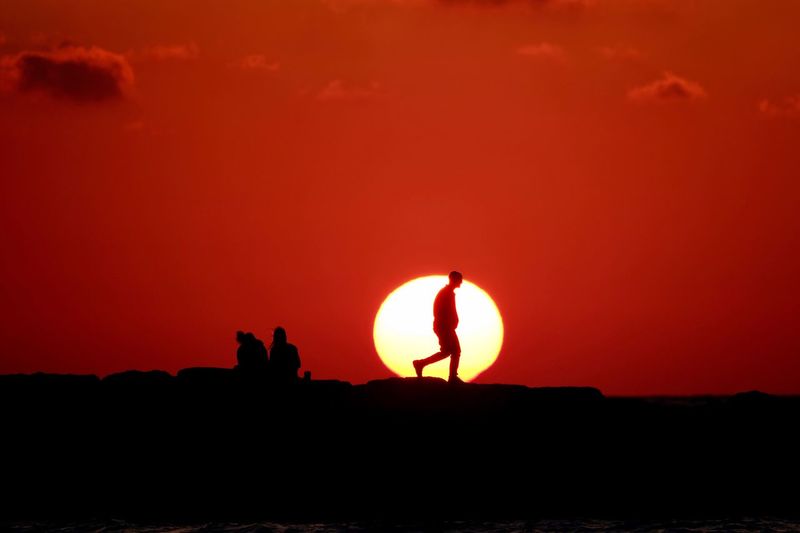 Silhouette man against sunset sky