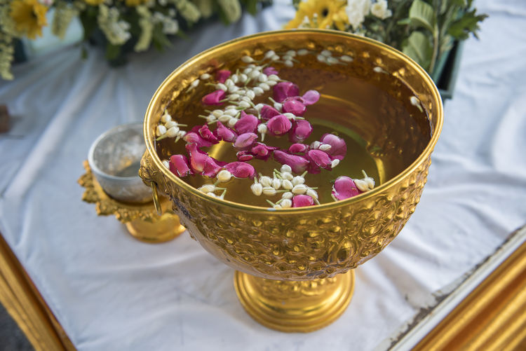 Flowers in gilded container filled with water during songkran festival