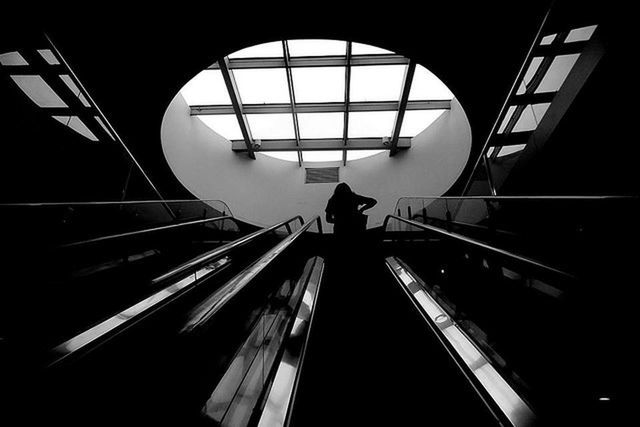Low angle view of silhouette woman on escalator