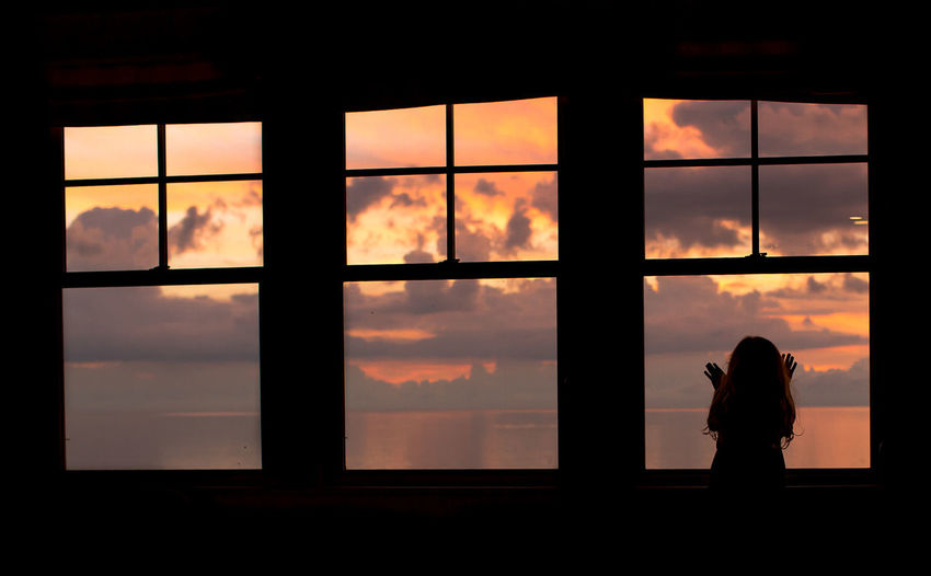 Silhouette of woman against cloudy sky
