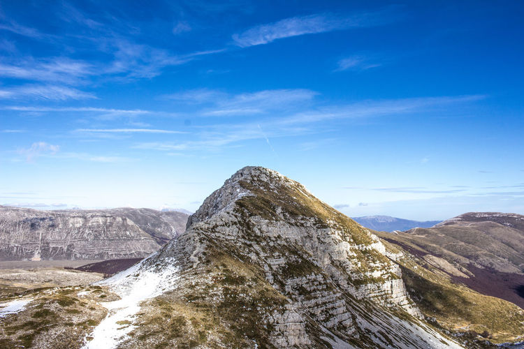 Scenic view of mountains against blue sky