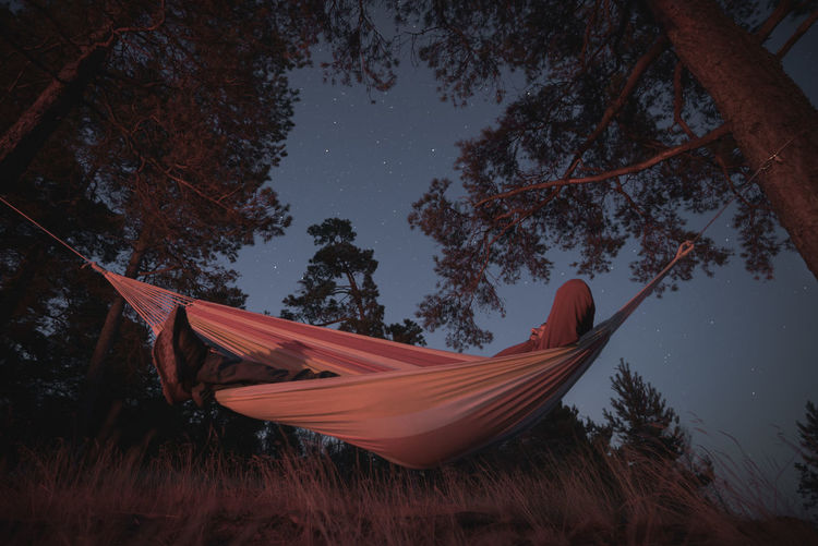 LOW ANGLE VIEW OF TENT ON FIELD AGAINST TREES