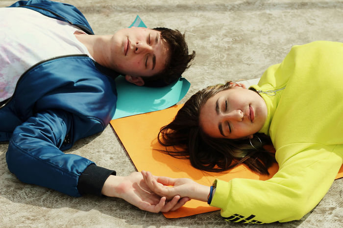 High angle view of friends sleeping on exercise mats