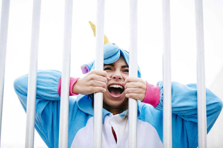 Woman wearing costume while standing behind bars