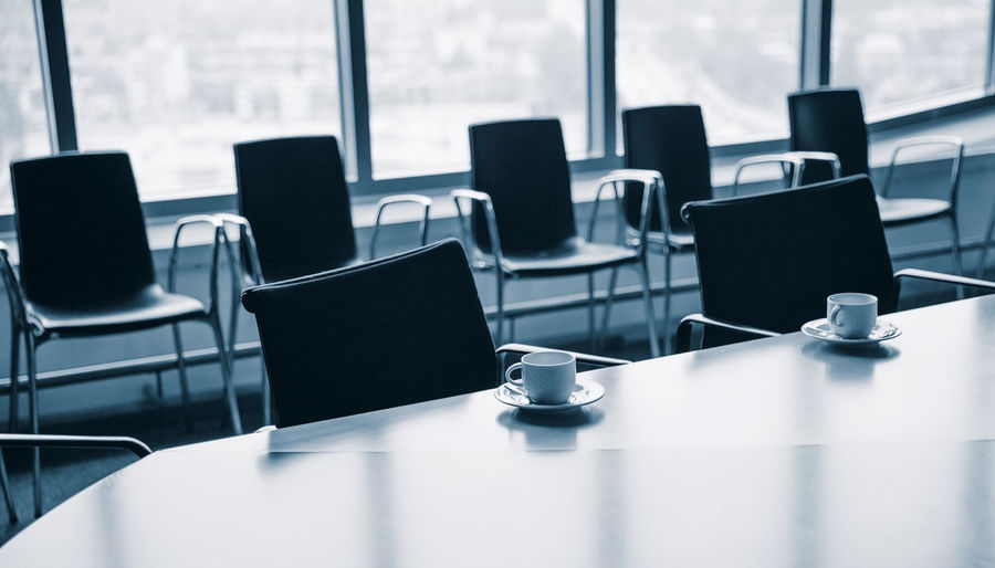 Empty chairs and coffee cup on table