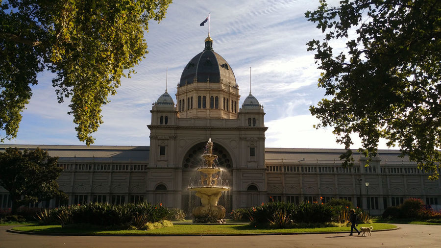 Fountain by royal exhibition building against sky