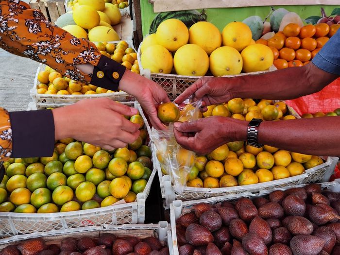 Buying oranges at a local market in indonesia