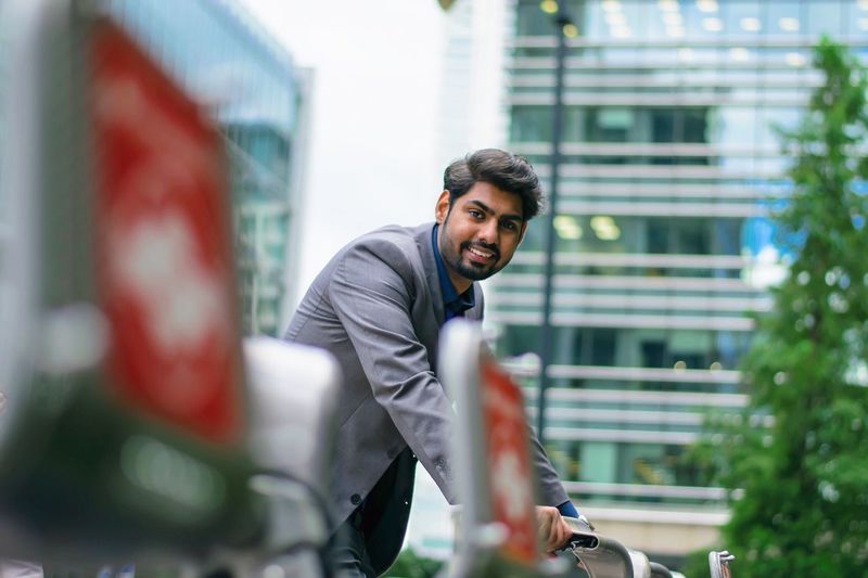 Portrait of smiling man standing against buildings in city
