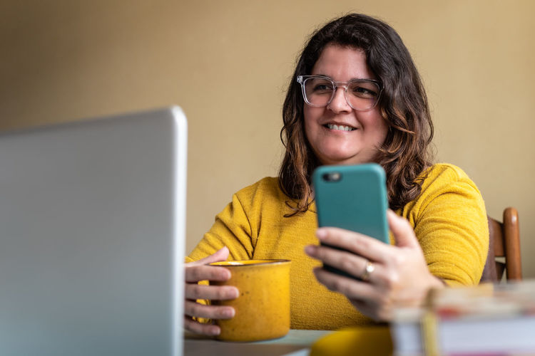 Portrait of smiling woman using mobile phone