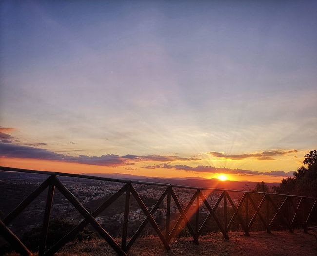 Scenic view of sunset seen through chainlink fence