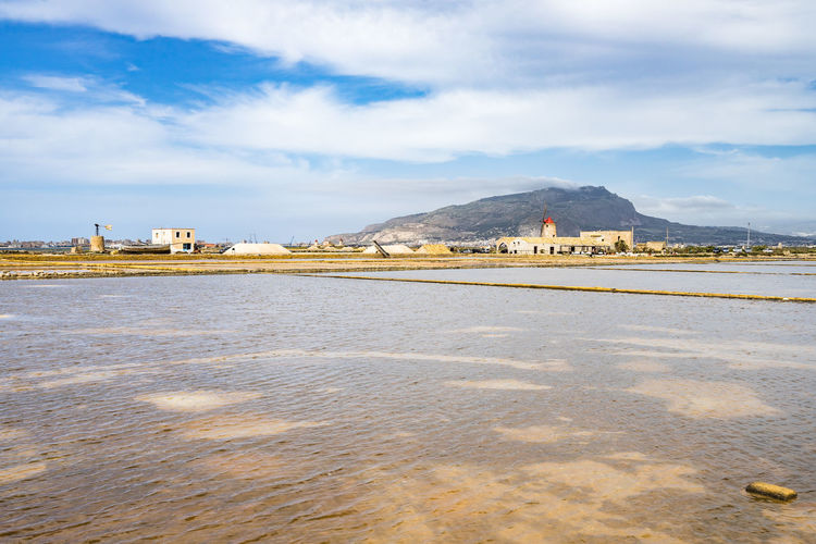 Amazing landscape of trapani saline with windmills and mount erice in the background, sicily, italy
