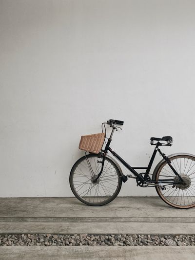 Bicycle parked against white wall in coffeeshop