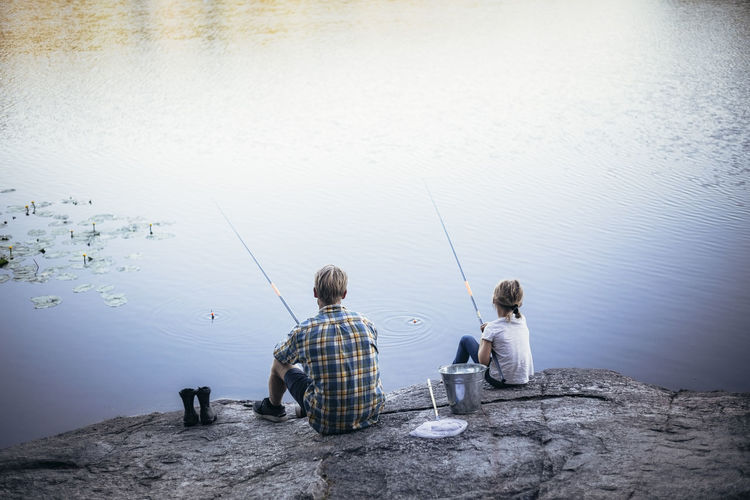 Rear view of men fishing in lake