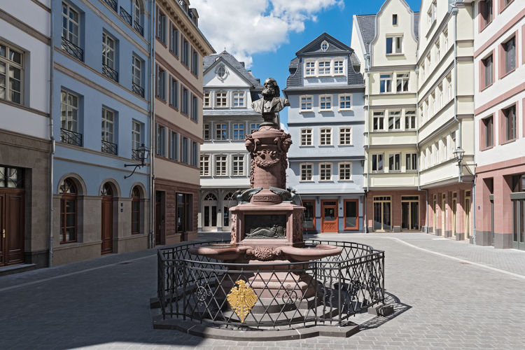 Statue by street against buildings in city