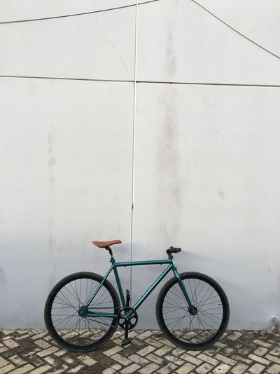 Bicycle parked by wall