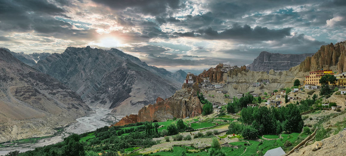 A remote himalayan village and monastery against dark clouds