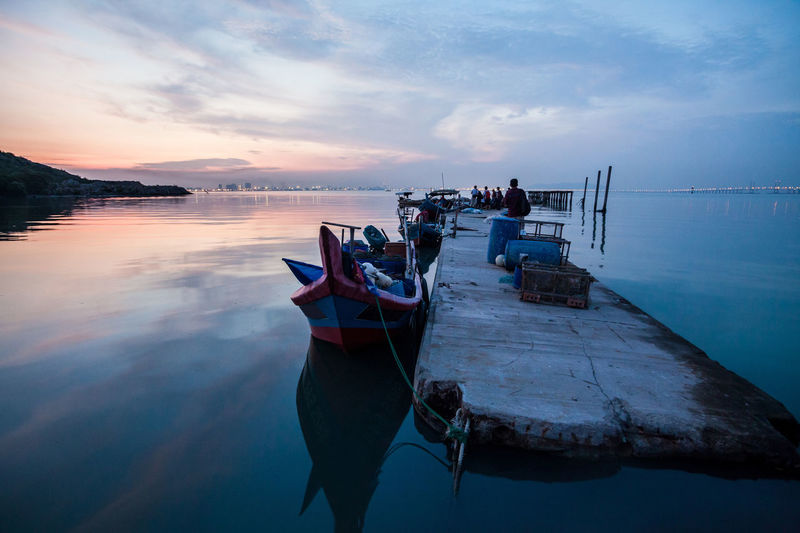 Boats moored on sea against sky