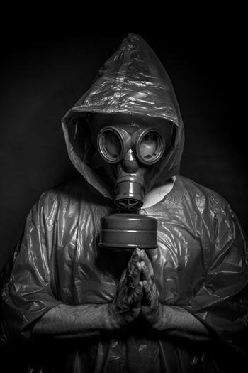 Man wearing gas mask against black background