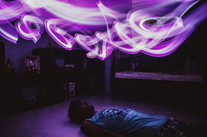 Light painting over man lying on floor at home
