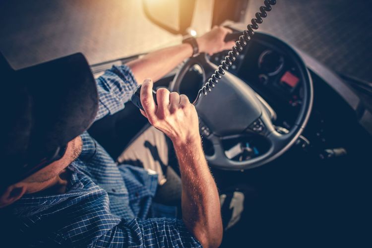 High angle view of driver holding radio walkie-talkie in truck