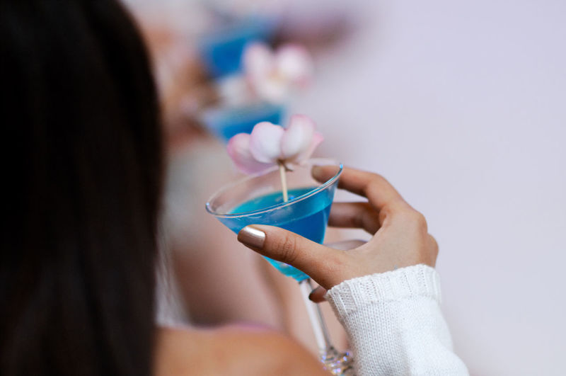 Cropped image of woman having cocktail in martini glass