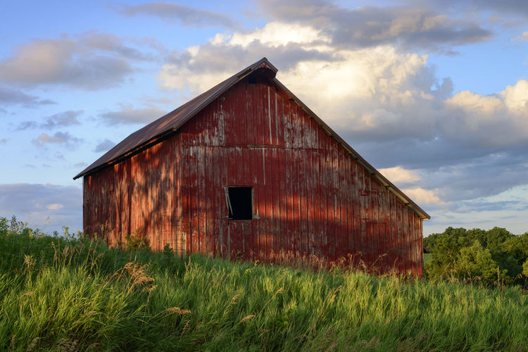 Abandoned barn on field against sky