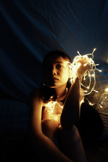 Portrait of beautiful woman holding illuminated light
