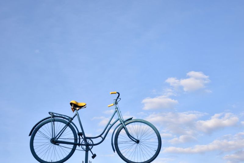Low angle view of bicycle parked against blue sky